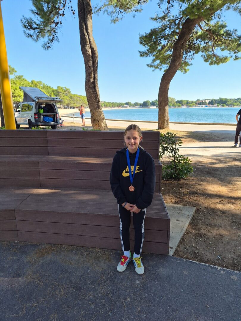 Djevojčica s medaljom uz jezero